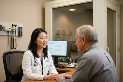 Audiologiste en blouse blanche expliquant les résultats d'un test auditif à un patient dans un cabinet médical moderne