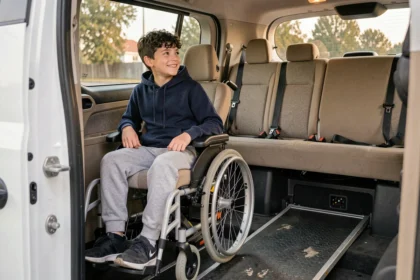 Adolescent en fauteuil roulant motorisé installé dans un véhicule adapté avec rampe hydraulique pour personnes handicapées