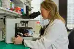 woman in white coat holding black dslr camera